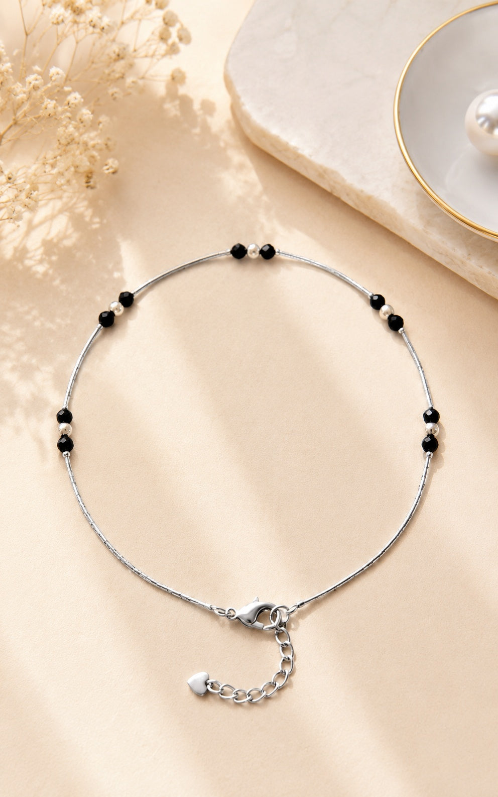 Silver anklet with black bead accents